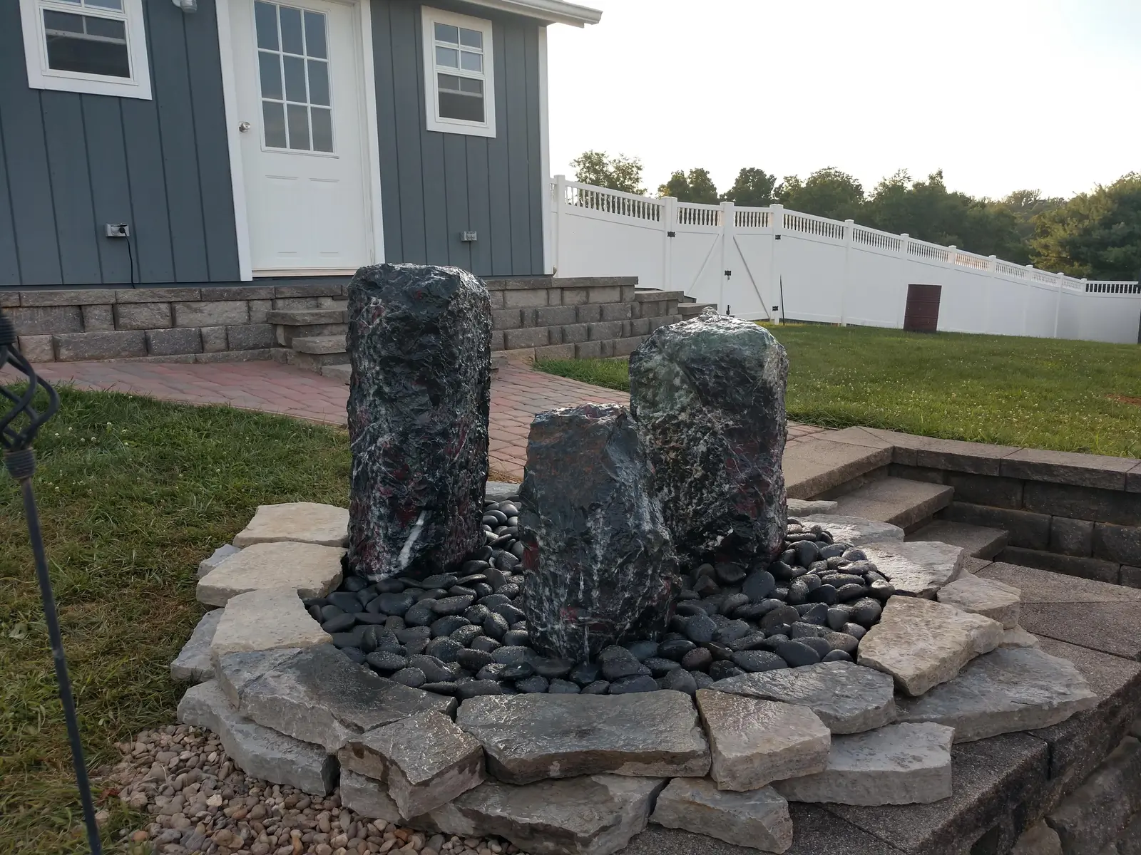 Basalt column water feature with river stone by Dave's Landscaping