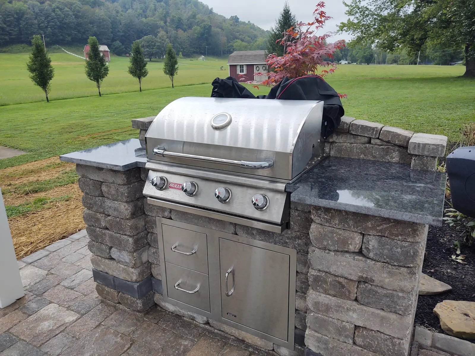 Built-in stainless grill with masonry work surfaces by Dave's Landscaping