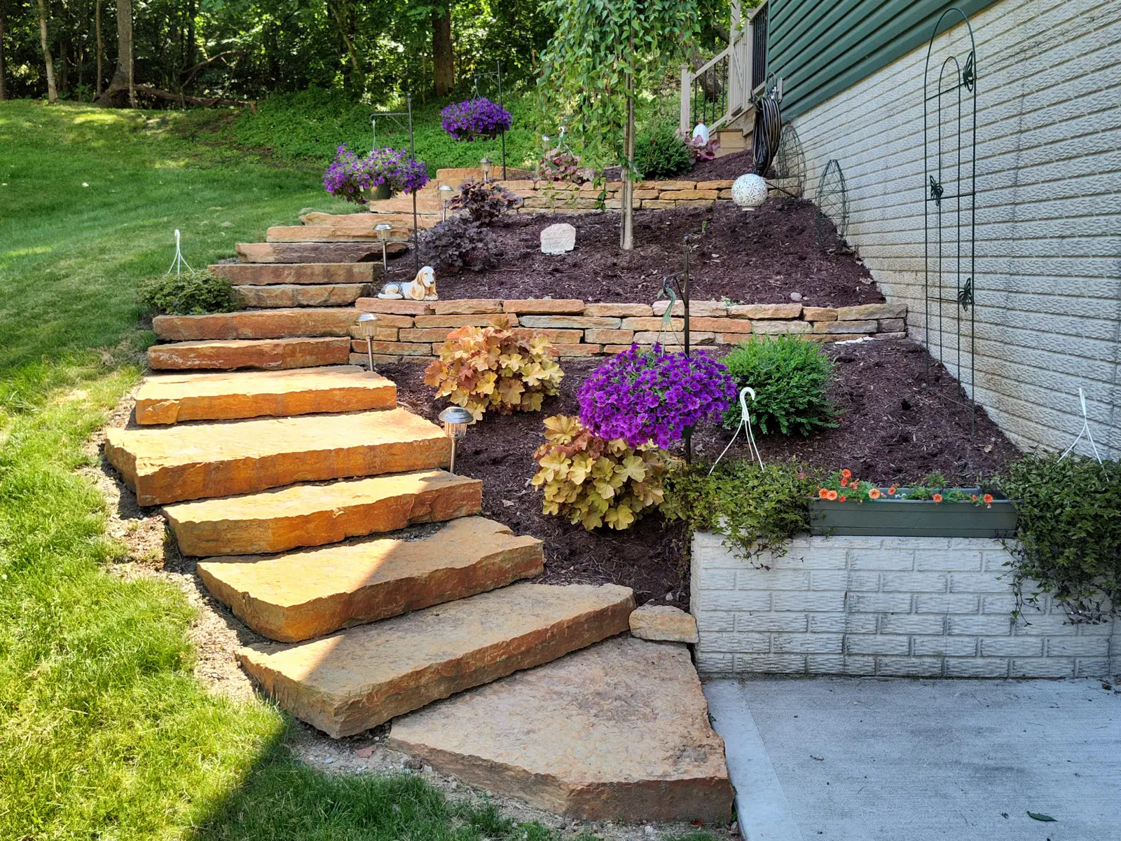 Broad stone steps with colorful perennial planting by Dave's Landscaping