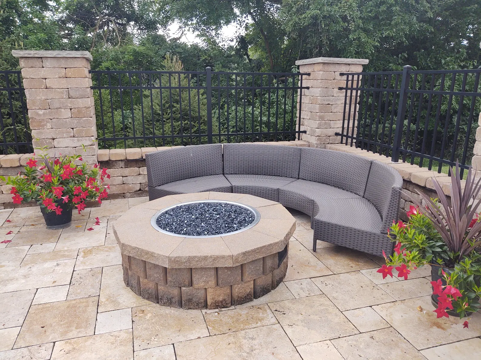 Circular gas fire pit with curved seating and masonry columns by Dave's Landscaping