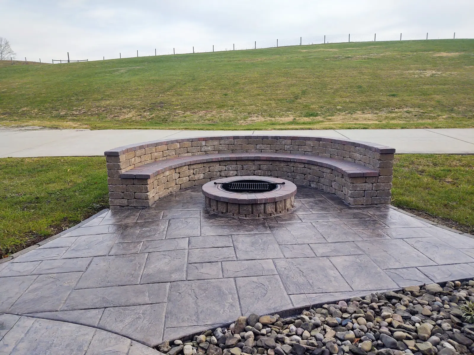 Fire pit courtyard with curved seat wall by Dave's Landscaping