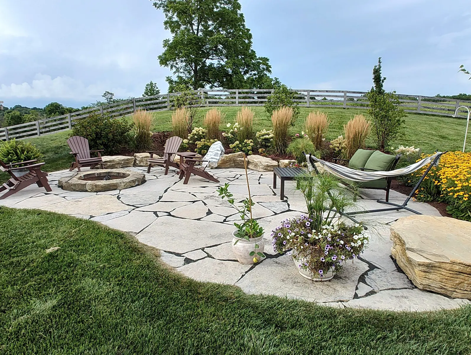 Flagstone patio woven into lush ornamental planting by Dave's Landscaping