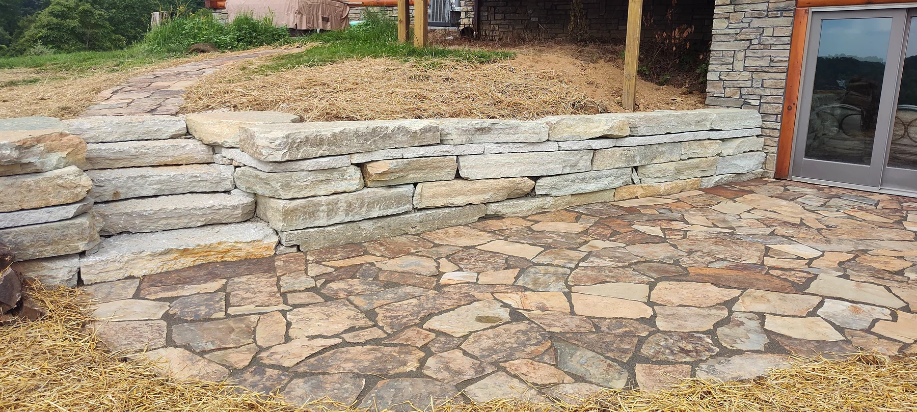 Natural stone retaining wall and flagstone paving by Dave's Landscaping