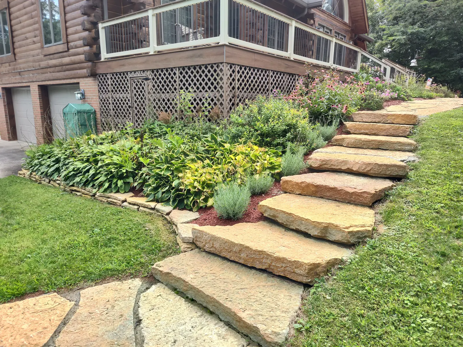 Natural slab steps climbing through a planted slope by Dave's Landscaping