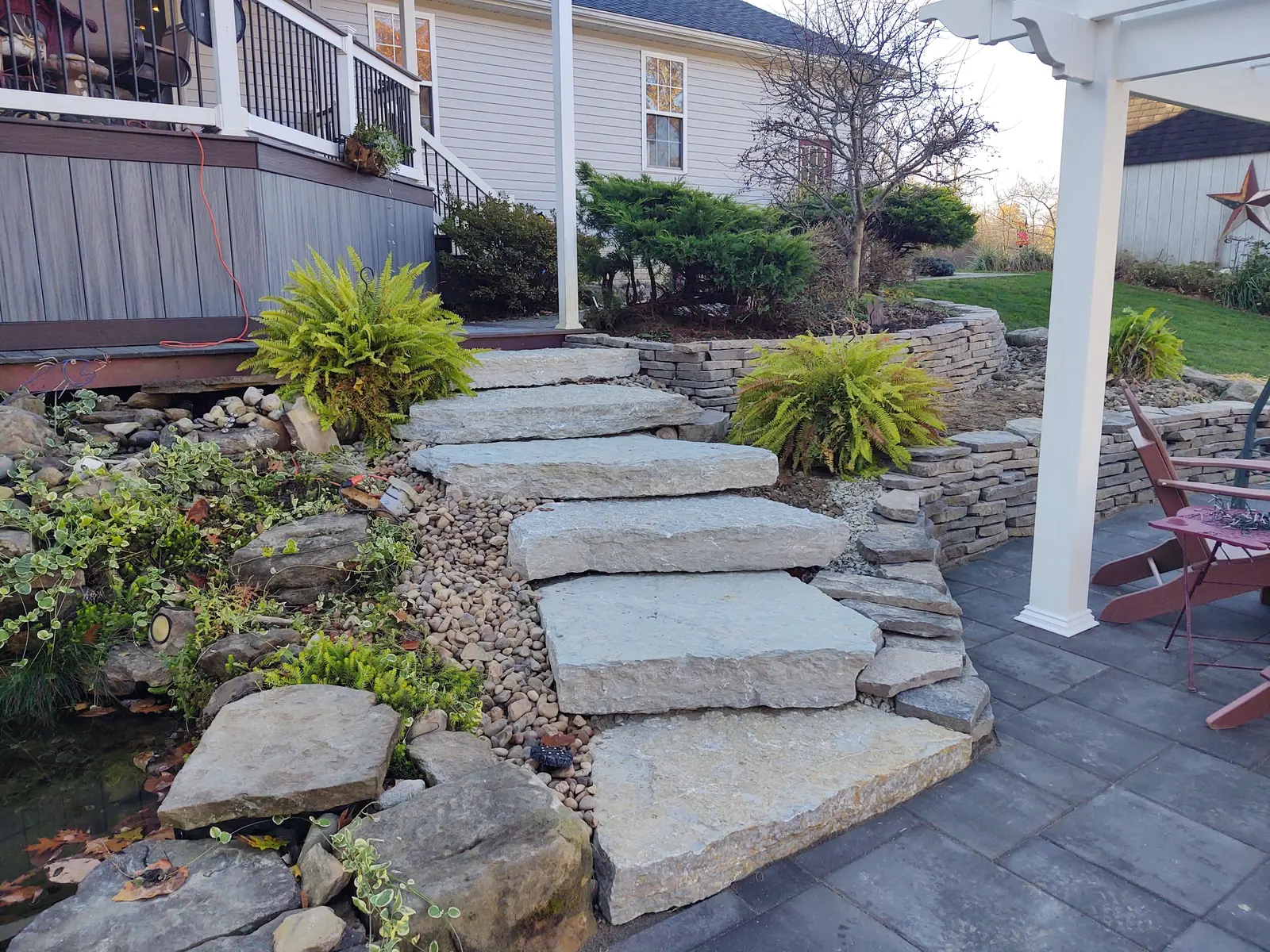 Layered natural-stone steps through a planted slope by Dave's Landscaping