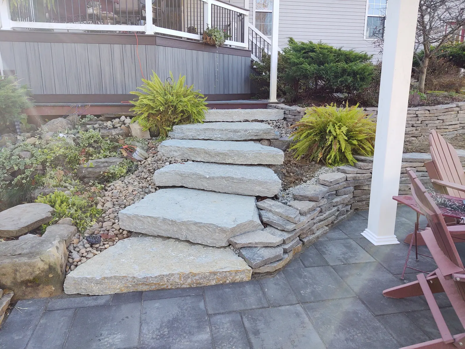 Natural-stone garden steps descending to a pergola patio by Dave's Landscaping