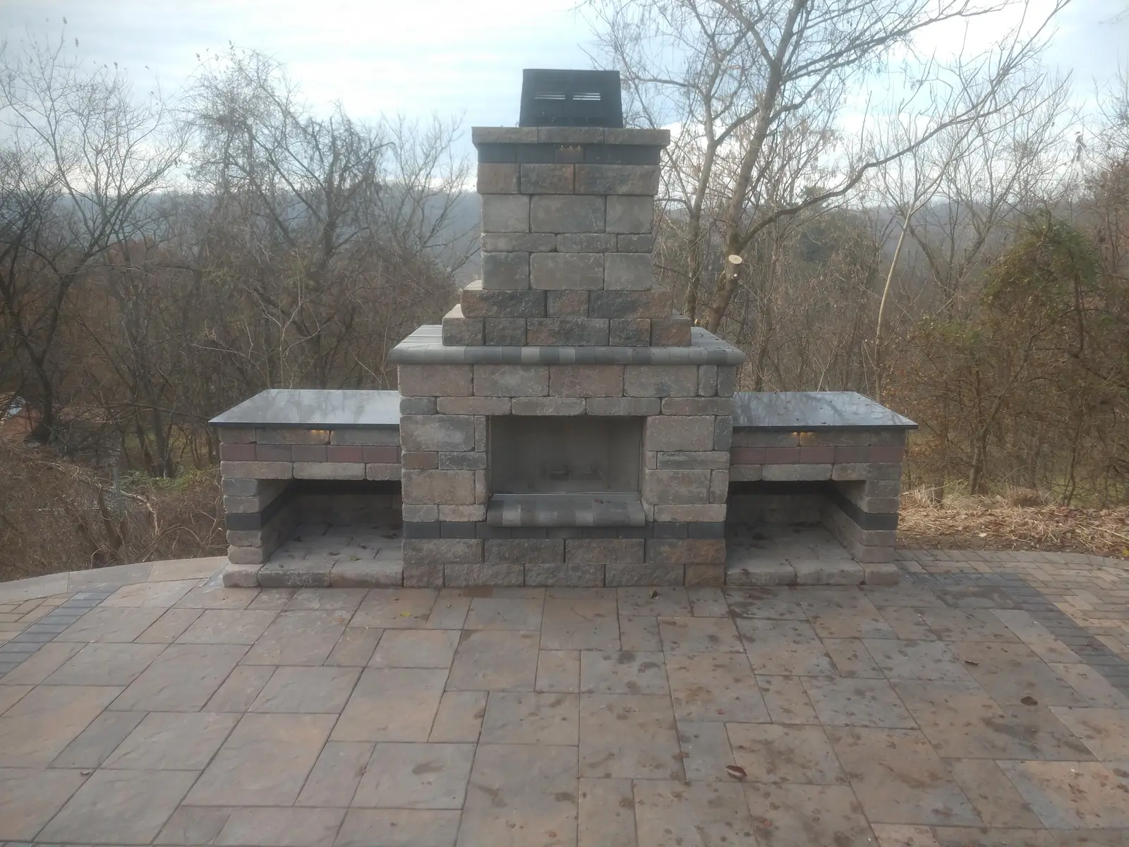 Masonry outdoor fireplace anchoring a paver patio by Dave's Landscaping