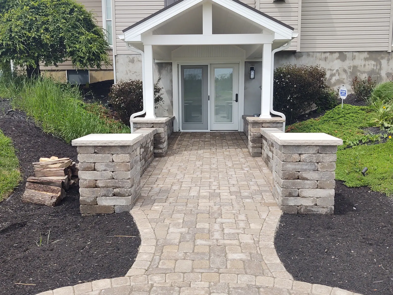 Paver front entry framed by masonry columns by Dave's Landscaping