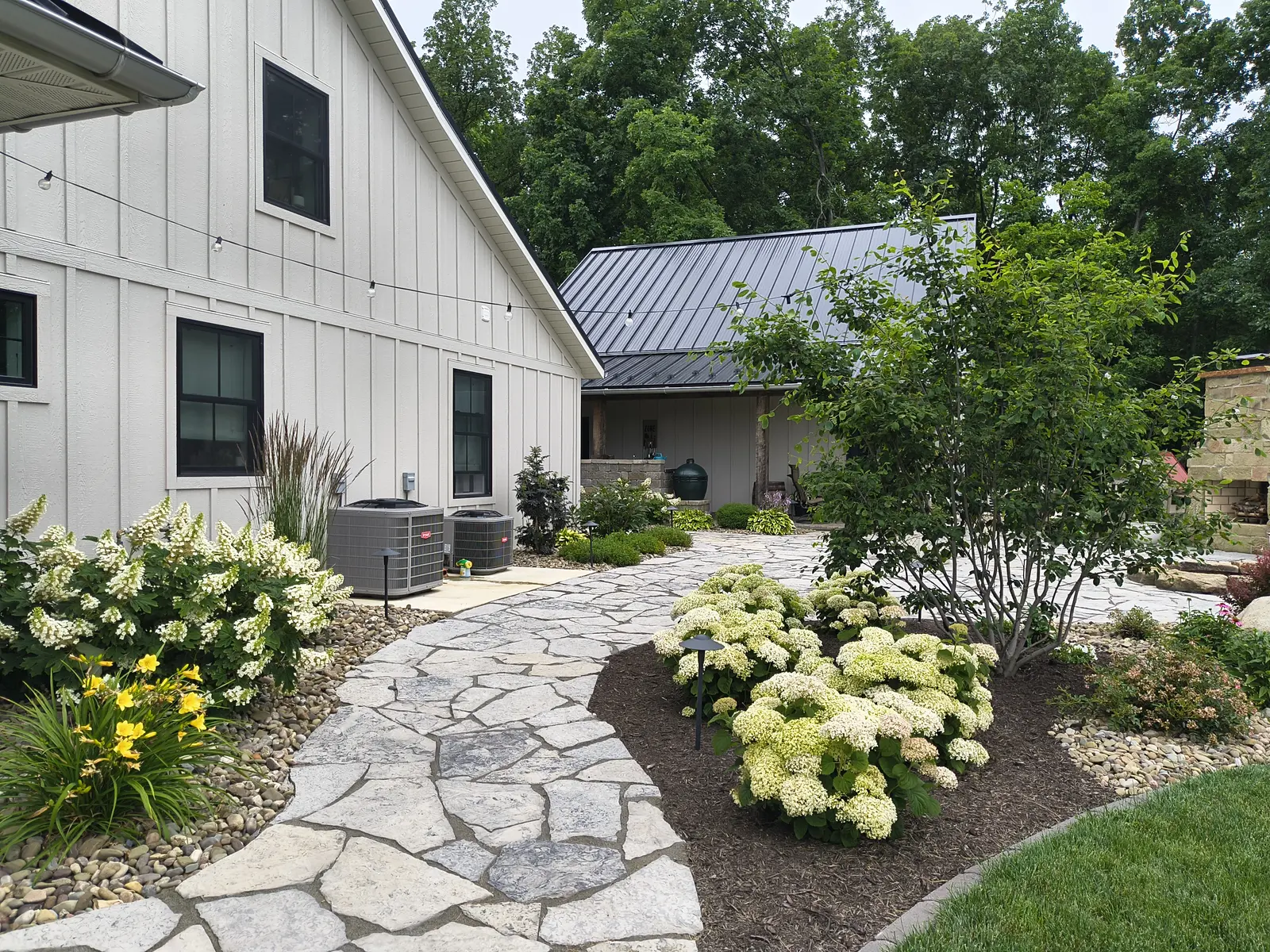 Hydrangeas and perennials along a natural-stone walk by Dave's Landscaping
