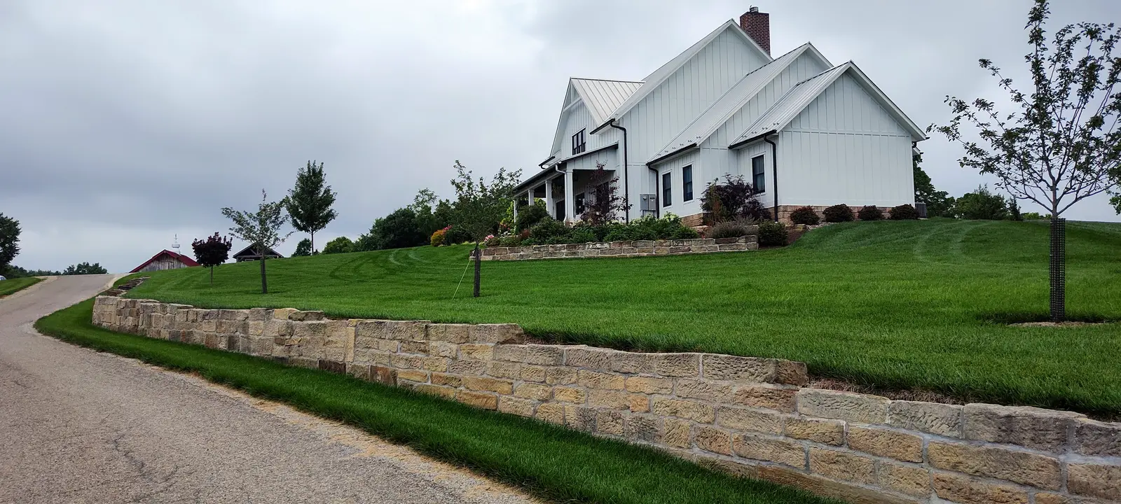 Crisp lawn, retaining wall, and foundation planting by Dave's Landscaping