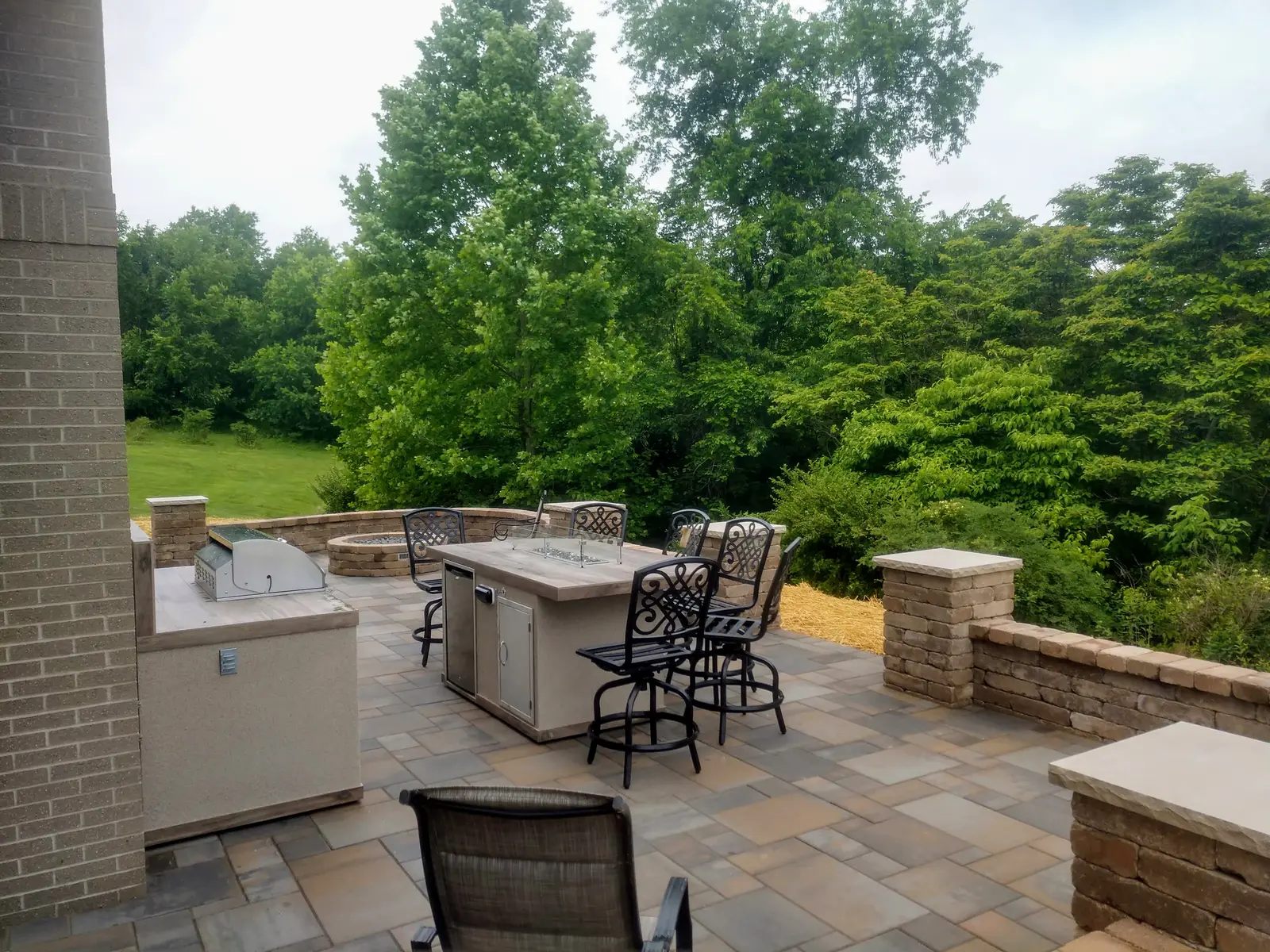 Outdoor kitchen and dining zone on an elevated terrace by Dave's Landscaping