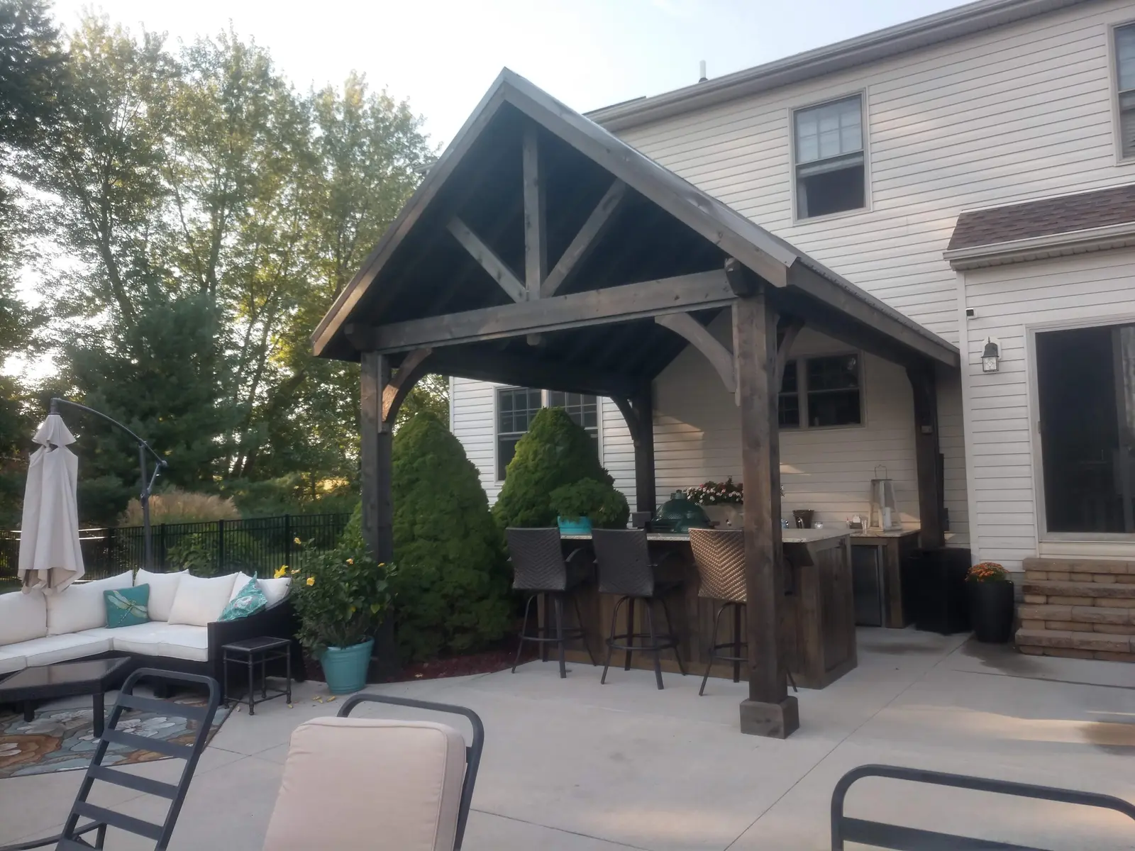 Covered lounge and bar beneath a timber pavilion by Dave's Landscaping